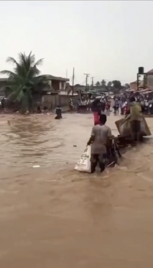 man on motorbike swept by flood water in lagos nigeria